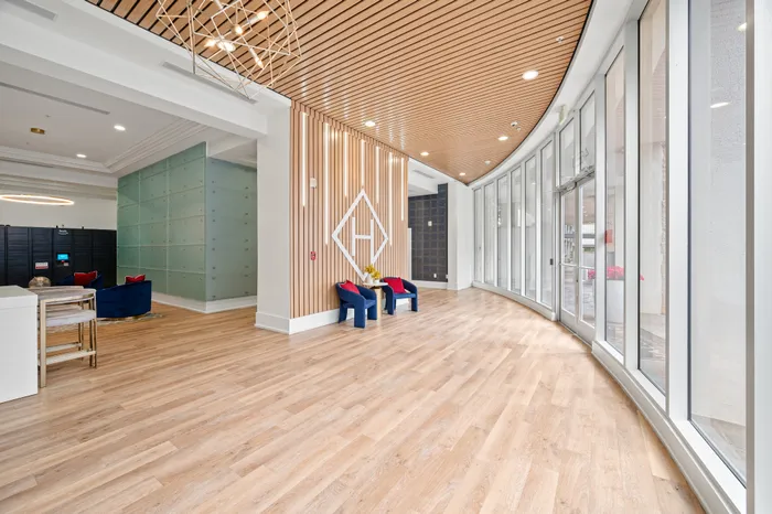 Modern lobby with elegant wood paneling, curved floor-to-ceiling windows, and stylish seating arrangement.