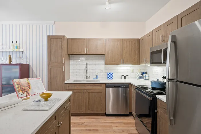 Modern kitchen with sleek stainless steel appliances, elegant wood cabinetry, and stylish white subway tile backsplash.