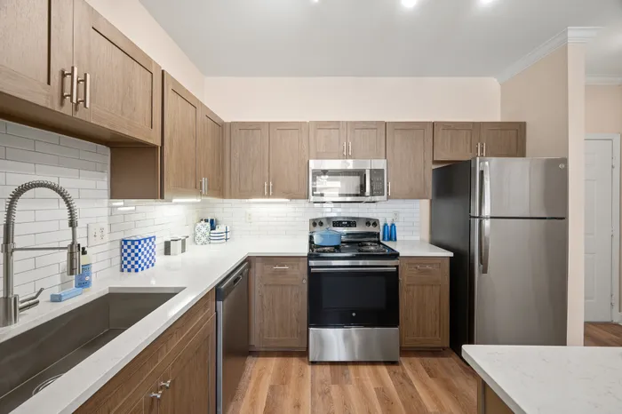 Modern kitchen with sleek stainless steel appliances, elegant wood cabinets, and a stylish white subway tile backsplash.