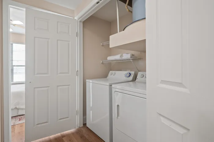 Bright and airy laundry nook with modern washer and dryer, complemented by sleek shelving for organized storage.