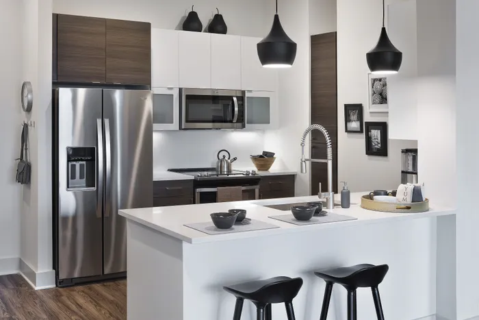 Elegant modern kitchen with sleek stainless steel appliances, minimalist countertops, and stylish pendant lighting, ideal for contemporary living.