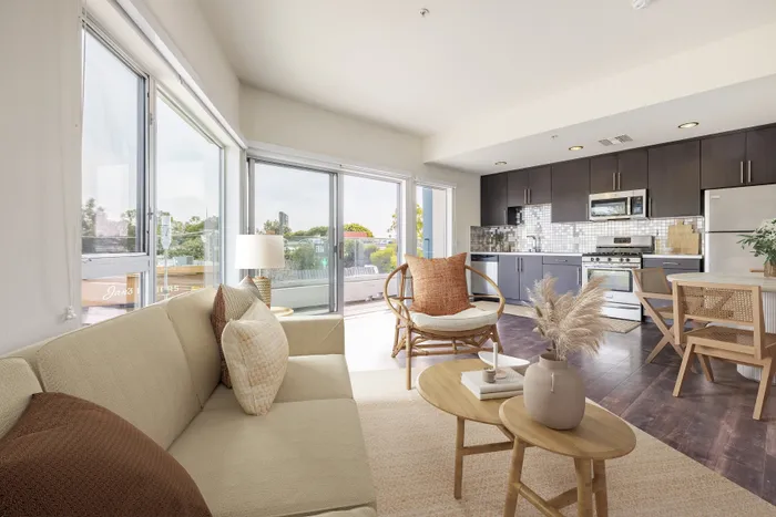 Bright, contemporary living space featuring modern kitchen with stainless steel appliances, cozy seating area, and large windows offering stunning views.
