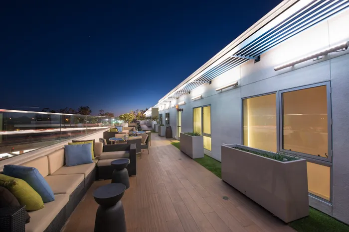 Chic rooftop patio with stylish seating, ambient lighting, and city views at night.