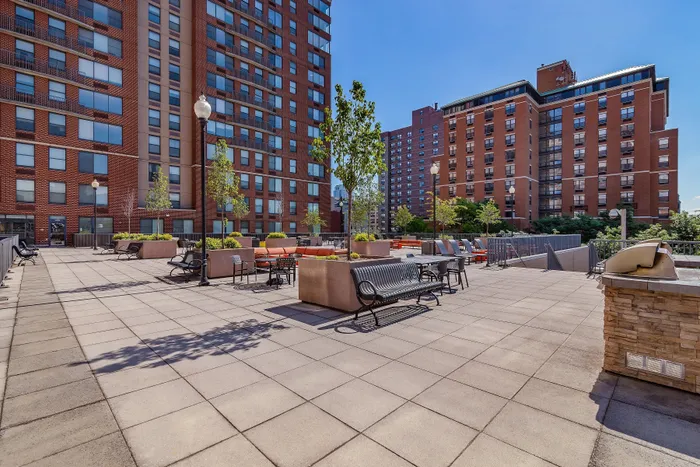 Chic urban terrace with stylish seating areas, lush planters, and vibrant cityscape backdrop.