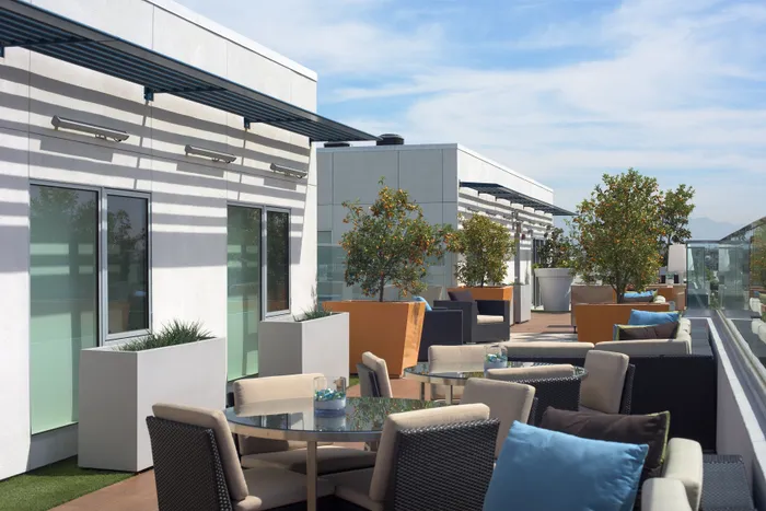 Luxurious rooftop terrace with stylish seating, lush greenery, and panoramic city views, perfect for relaxation and entertaining.