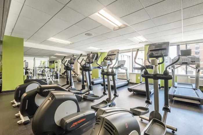 Modern fitness center with state-of-the-art equipment, bright interior, and large windows for natural lighting.