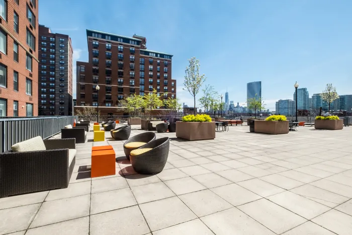 Chic urban rooftop terrace with stylish seating, lush planters, and stunning city skyline views.