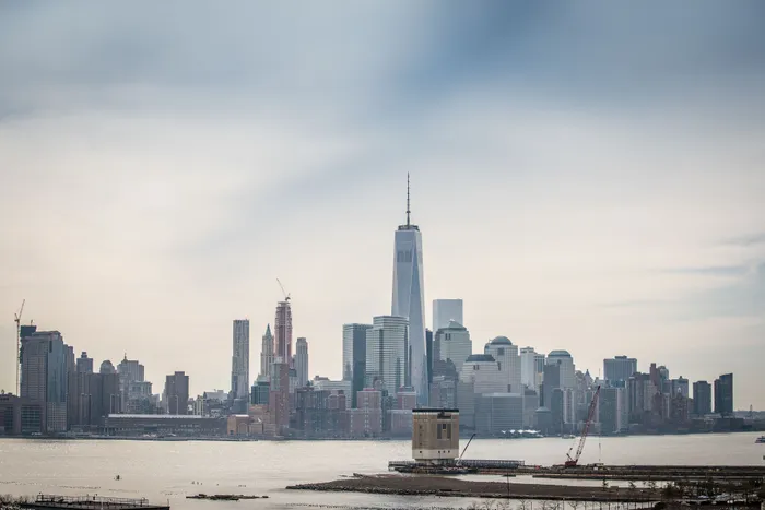 Breathtaking city skyline with towering modern skyscrapers under a tranquil sky, showcasing a vibrant urban oasis by the waterfront.