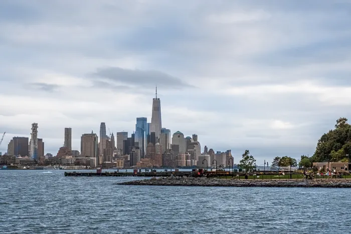 Stunning waterfront cityscape view featuring an iconic skyline with tall skyscrapers under a vibrant sky.