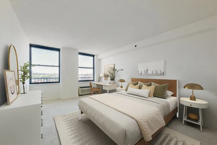 Dog-Friendly Luxury Apartments In Hoboken, NJ - 77 Park Avenue - A Bright, Modern Bedroom Featuring A Wood-Frame Bed, A White Desk With A Chair, And Two Large Windows With City Views.