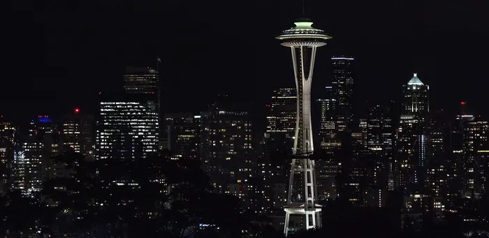 Dazzling night skyline view with iconic tower amidst a sea of illuminated skyscrapers, perfect for urban city living enthusiasts.