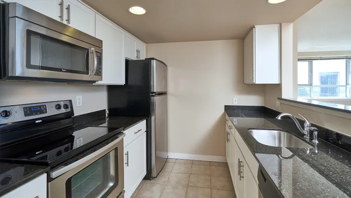Luxury Apartments in Seattle, WA, with In-Unit Washer and Dryer - Centennial Tower and Court - Kitchen with White Cabinetry, Single-Sink, Stainless Steel Appliances, and Recessed Lighting.