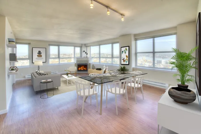 Bright and inviting living and dining area with panoramic city views, featuring modern decor, a cozy fireplace, and abundant natural light.