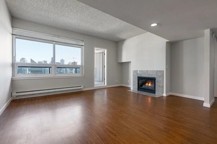 Modern apartment living room with stunning cityscape views, cozy fireplace, and sleek hardwood floors.