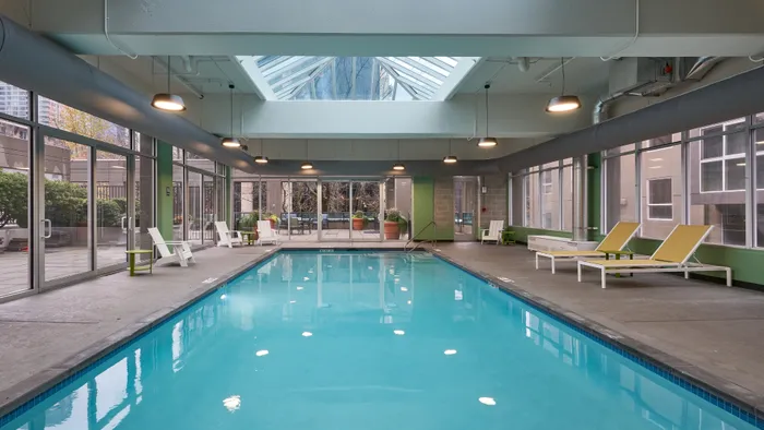 Inviting indoor pool area with elegant skylights and stylish lounge chairs, perfect for relaxation and entertainment.