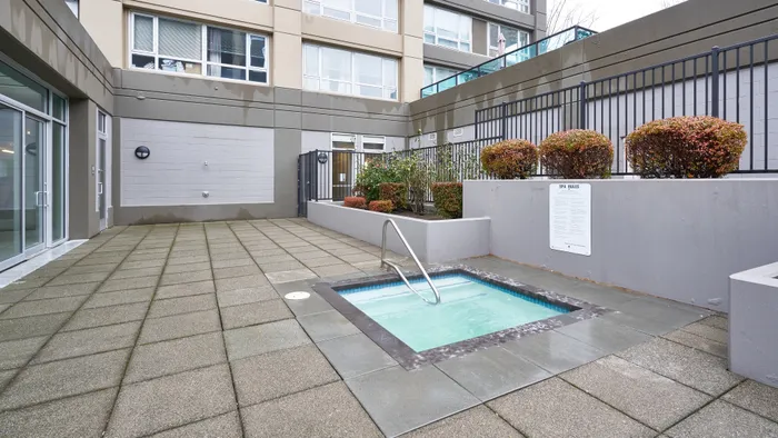 Modern apartment patio featuring a cozy, inviting hot tub surrounded by elegant landscaping and sleek architecture.