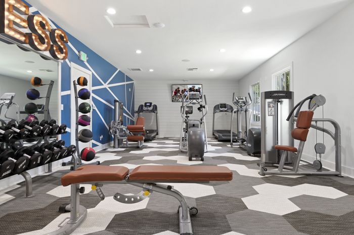 Contemporary fitness center featuring state-of-the-art equipment, colorful geometric wall design, and modern flooring.