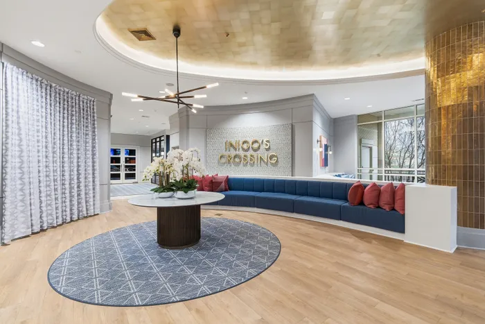 Elegant lobby at Indigo's Crossing with modern chandelier, stylish curved seating, and a cozy atmosphere.