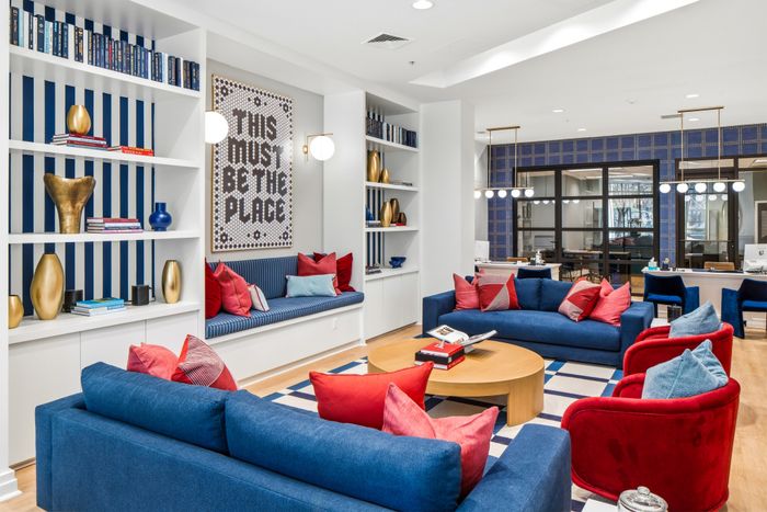 Vibrant living area with chic blue and red seating, modern decor, and inviting ambiance perfect for relaxation and entertaining.