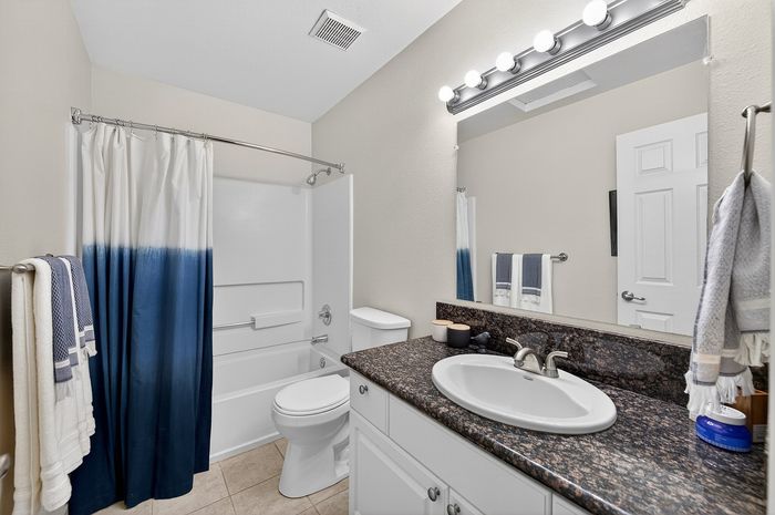 Contemporary bathroom with luxurious granite countertop, elegant lighting, and modern fixtures for a sophisticated touch.