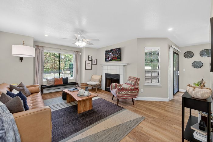 Inviting living room with elegant decor, featuring a cozy seating area, stylish coffee table, and modern fireplace, enhanced by large windows and natural light.