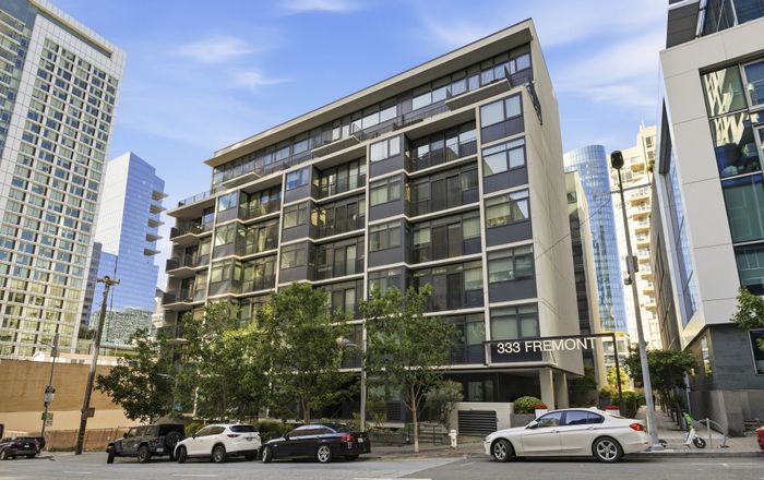 Modern urban apartment building with sleek architecture and floor-to-ceiling windows offering vibrant city living.
