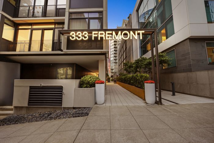 Elegant modern apartment entrance at 333 Fremont featuring lush greenery and sleek architecture.