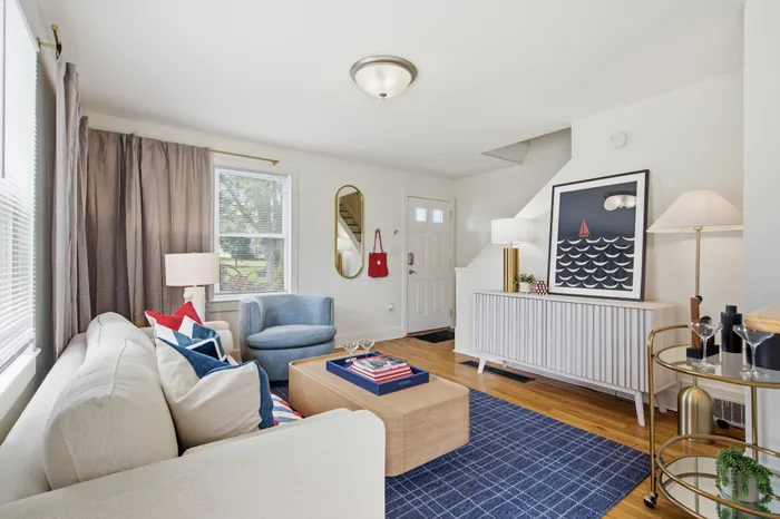 Bright, inviting living room with chic decor, stylish furniture, and natural light streaming through large windows.