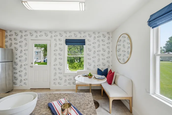 Charming breakfast nook with elegant decor, featuring a round table, stylish seating, and chic patterned wallpaper.