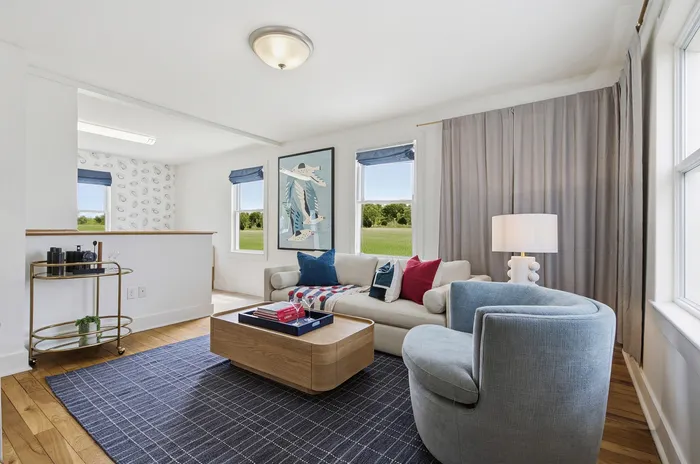 Bright and inviting living room with large windows, modern decor, and plush seating, perfect for relaxation.