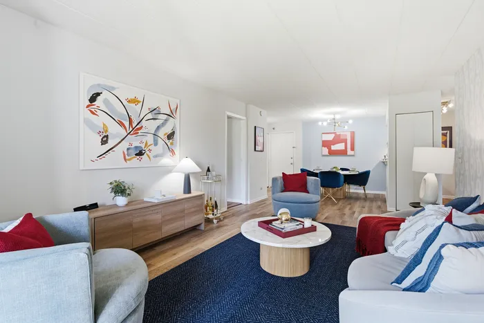 Contemporary living room with vibrant art, elegant seating, and stylish decor; perfect blend of comfort and modern design.