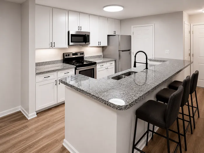 Elegant modern kitchen with granite countertops, stainless steel appliances, and bar seating for three.