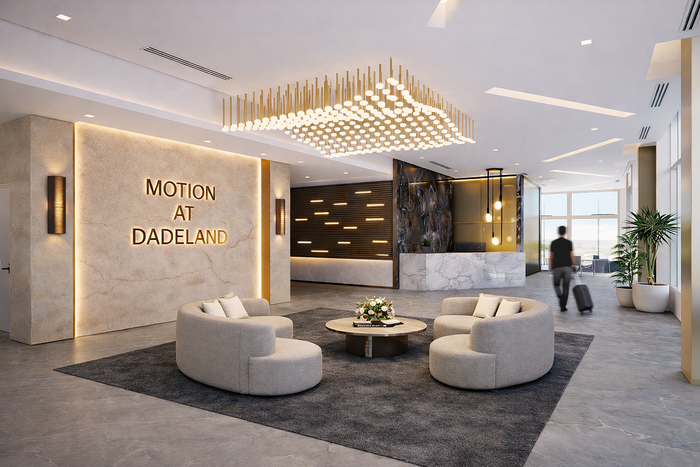 Luxurious lobby at Motion at Dadeland featuring elegant seating, a modern chandelier, and a chic marble reception desk.