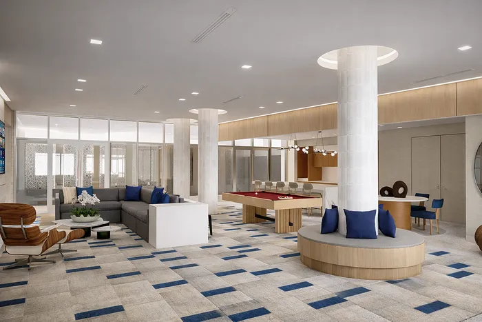 Modern communal lounge with stylish gray sectional sofa, vibrant blue accents, chic seating area, and elegant pool table in a spacious open-concept design.