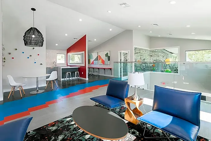 Modern and vibrant living area featuring chic blue seating, stylish lighting, and a colorful, open-concept layout perfect for entertaining.