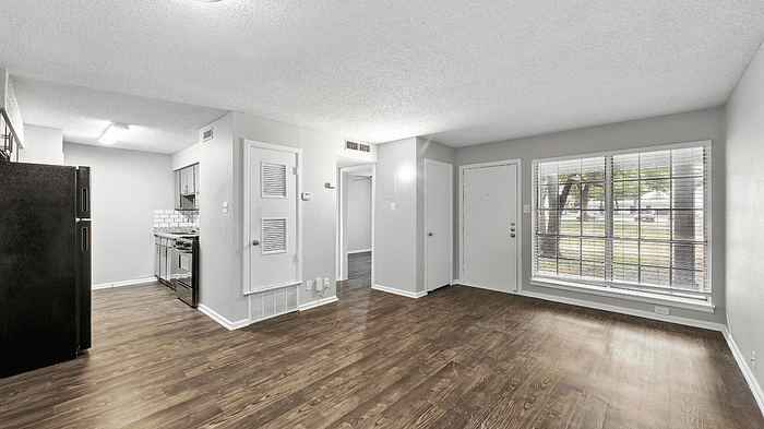 Bright, open-concept living area with modern kitchen, sleek flooring, and large windows offering serene views.