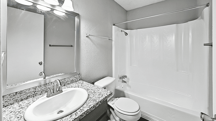 Elegant bathroom with granite countertop, modern fixtures, and a pristine bathtub offering a serene retreat.