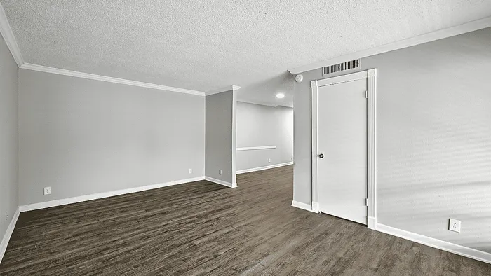 Bright and spacious room featuring elegant wood flooring and modern gray walls, ideal for a stylish living area.
