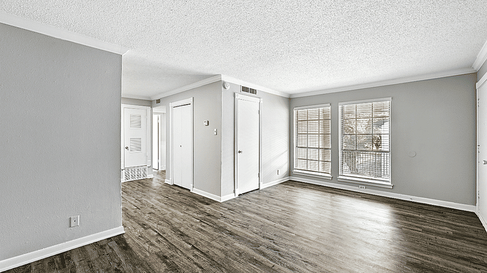 Charming and bright living space with large windows and elegant hardwood floors.