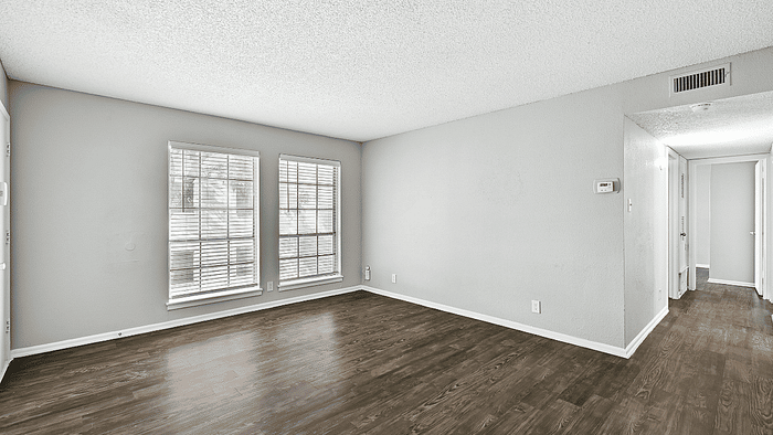 Bright and inviting living room with large windows, sleek hardwood floors, and a modern neutral palette.