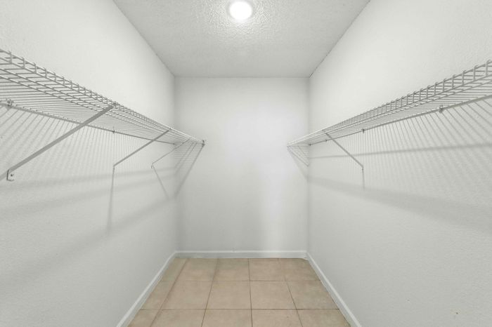 Spacious walk-in closet with ample shelving, ideal for organized storage and stylish living.