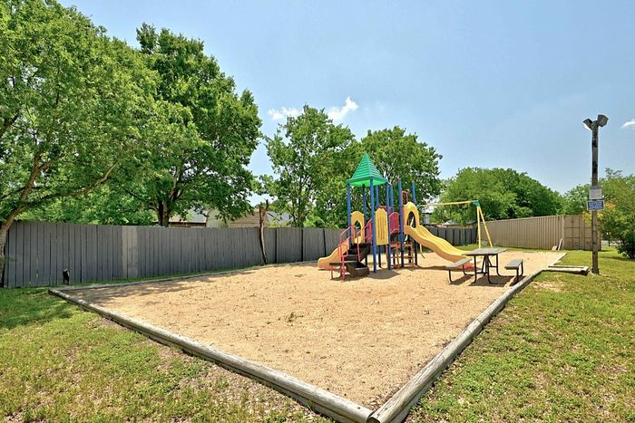 Charming outdoor playground with colorful slides and swings nestled among lush greenery, perfect for family fun.