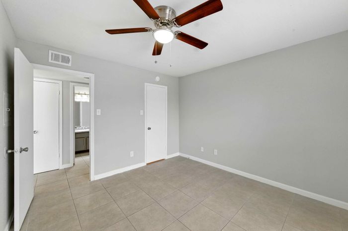 Bright and airy room with modern ceiling fan and neutral walls, perfect for personalization.