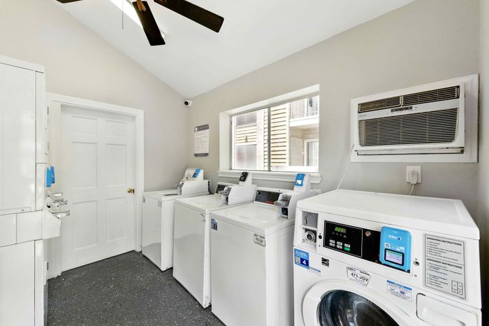 Bright and well-equipped laundry room featuring modern washing machines and ample natural light, perfect for convenient living.
