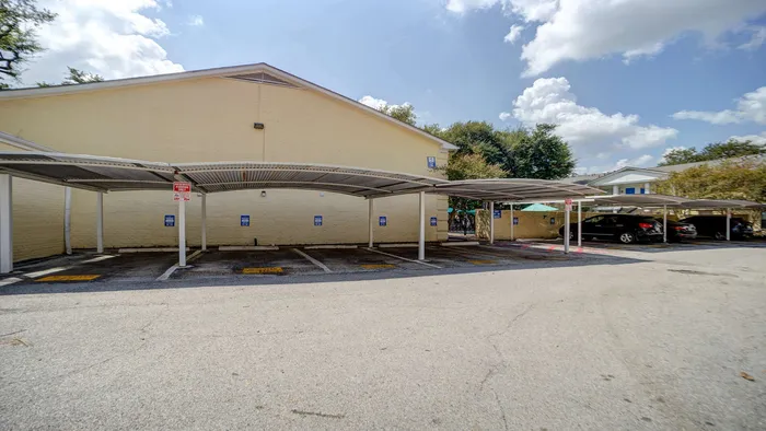 Well-maintained parking area with covered spaces under a clear blue sky, offering excellent protection for your vehicles.
