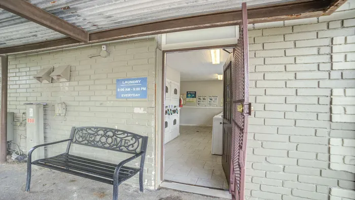 Inviting communal laundry room with modern machines and welcoming seating area, open daily for convenience.