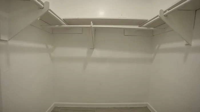 Spacious walk-in closet with shelving and ample hanging space, perfect for organizing your wardrobe.
