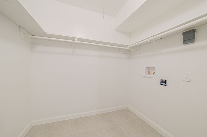 Spacious walk-in closet with ample hanging space, perfect for organizing your wardrobe in a modern apartment setting.