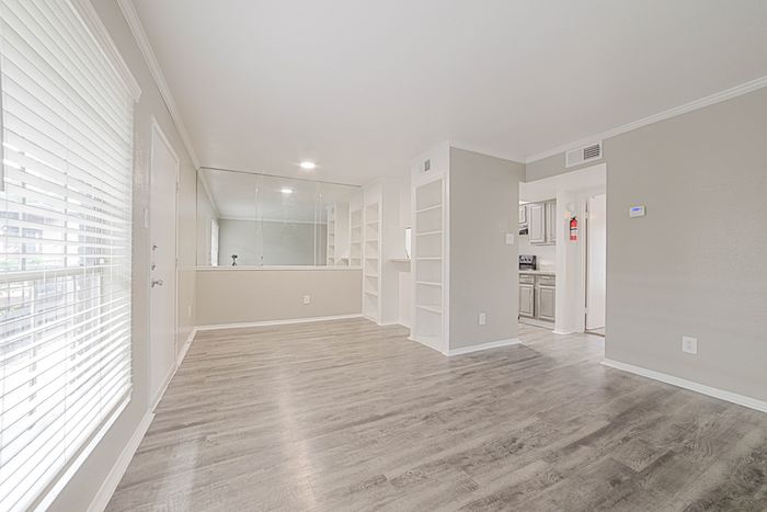 Bright and airy apartment with elegant hardwood floors, built-in shelves, and a modern kitchen.