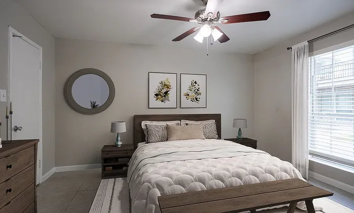 Inviting bedroom with a plush bed, elegant decor, and abundant natural light from large windows.